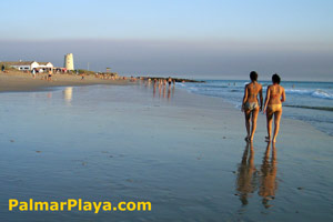 Paseo por la playa del Palmar, al fondo Torre Nueva.